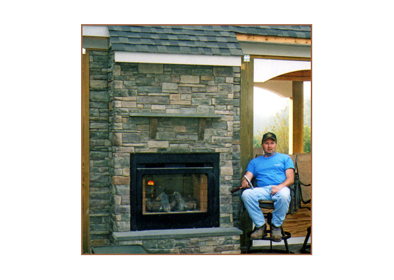 Stone mason by one of his fireplaces